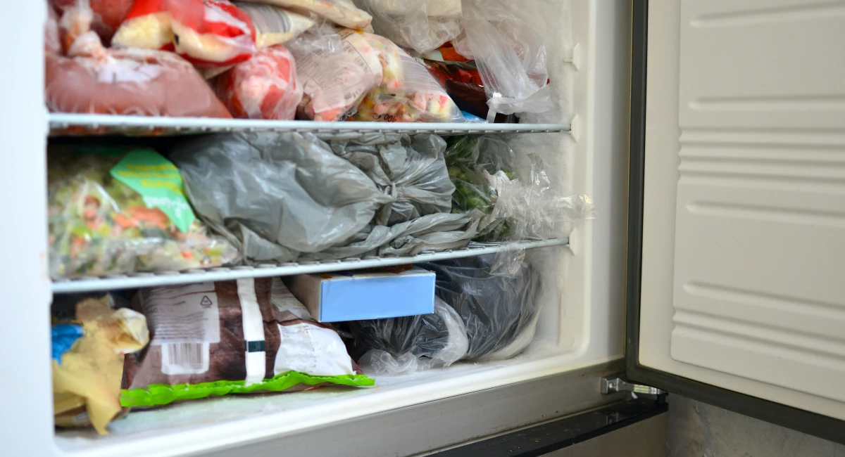 A freezer with its door open, showing shelves full of goods