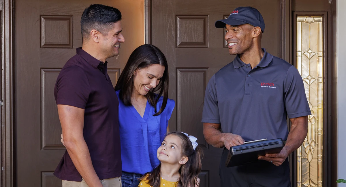 technician standing outside the front door with the homeowner's family