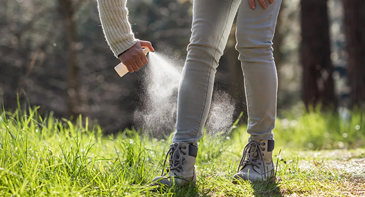 Woman applying insect repellent