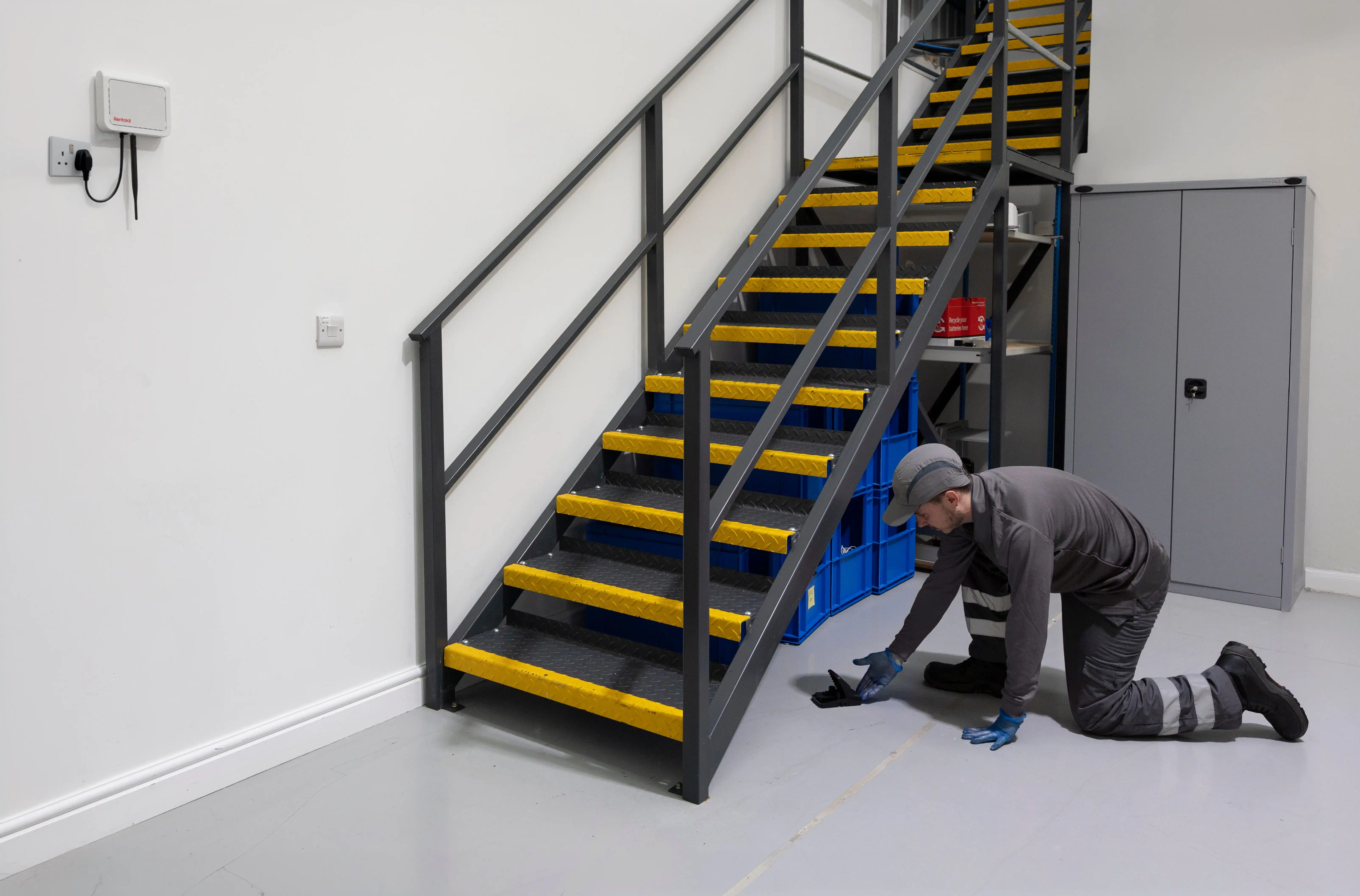 A technician placing a connected rodent trap.